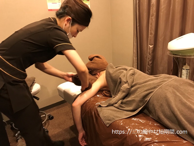 施術後にタオルで二の腕を拭いてもらう様子