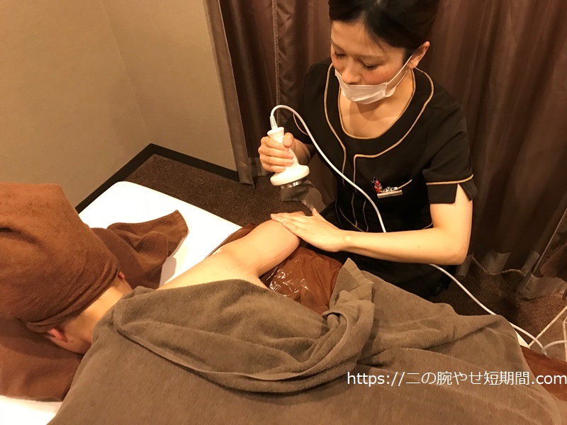 二の腕にキャビーション施術を受ける様子