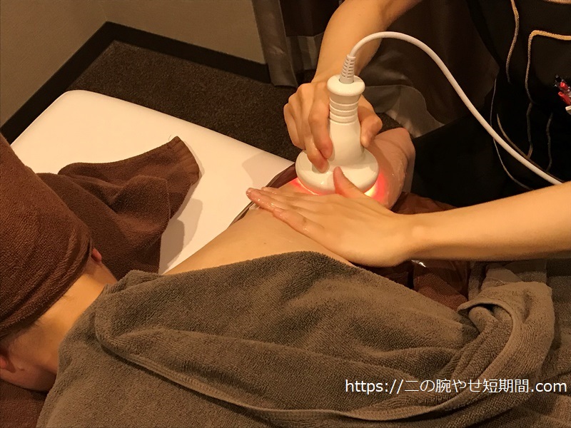 二の腕にキャビーションを当ててもらってる様子